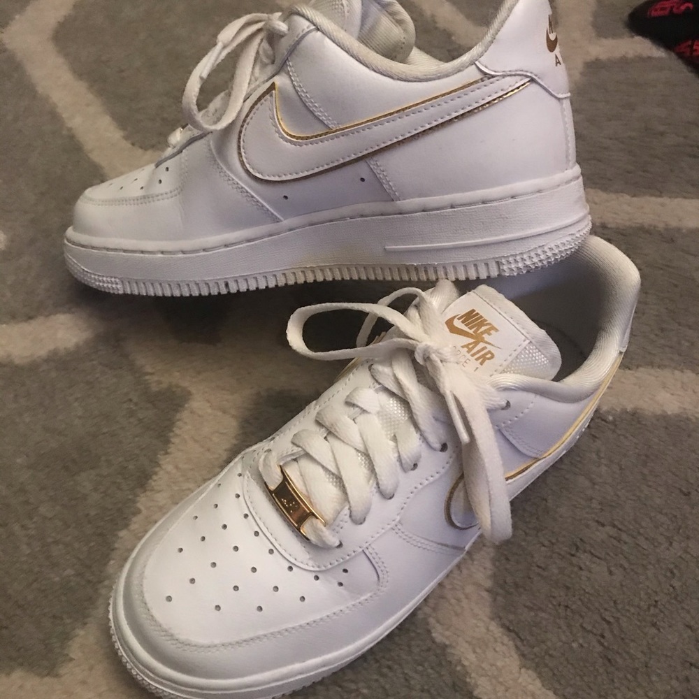 gold and white Nike Air Force 1’s